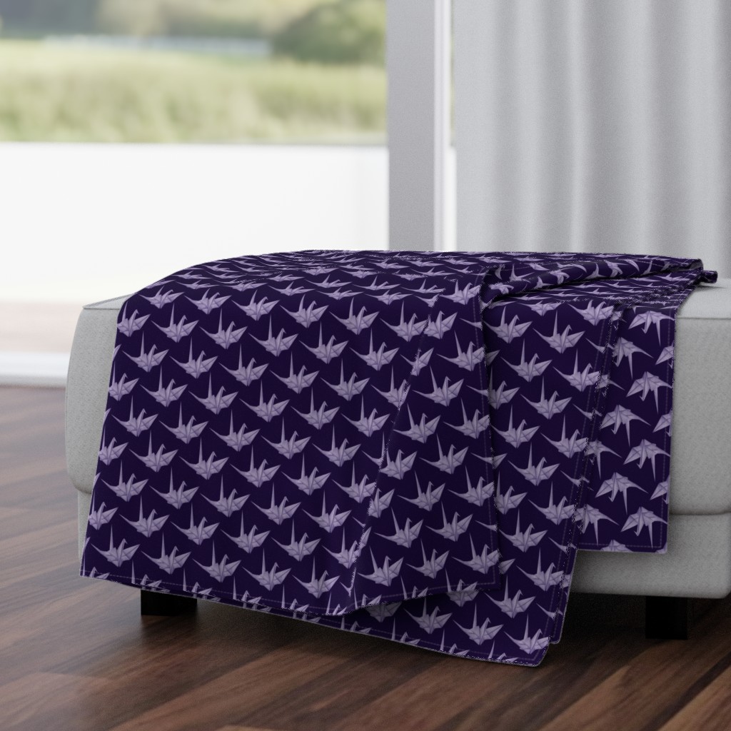 Throw blanket with lilac Japanese origami paper cranes on dark purple background